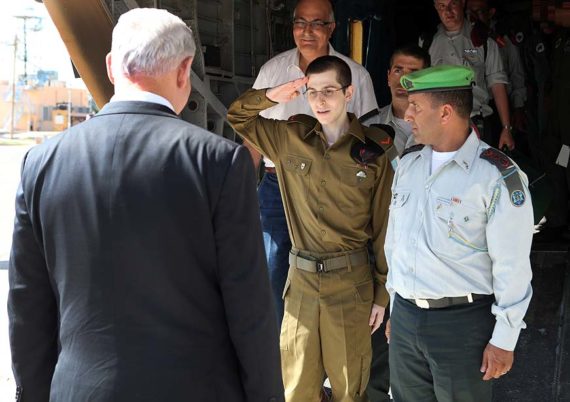 Israeli soldier Gilad Shalit salutes Israeli Prime Minister Benjamin Netanyahu on arrival at Tel Nof air force base