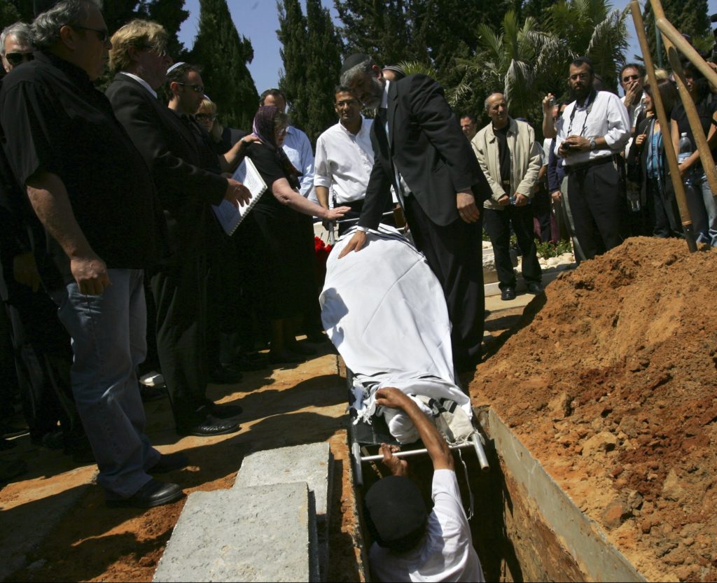 RAANANA, ISRAEL - APRIL 20: The shroud-covered body of Virginia Tech Professor of Engineering Liviu Librescu is lowered into his grave during his funeral on April 20, 2007 in the municipal cemetery in Raanana, Israel. Librescu, an internationally respected aeronautics engineer and a lecturer at Virginia Tech for 20 years, was a Holocaust survivor who later escaped to Israel from Communist Romania. Librescu has been hailed as a hero for saving the lives of several students by blocking shooter Cho Seung-Hui before he was gunned down in the attack which left 32 students and faculty members dead on the Virginia Tech campus on April 16, 2007 in Blacksburg, Virginia, USA. (Photo by David Silverman/Getty Images)