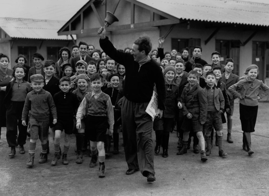 11th January 1939: A camp leader ringing the dinner bell at a camp for young Jewish 'Kindertransport', refugees from Germany and Austria, at Dovercourt Bay near Harwich. (Photo by Reg Speller/Fox Photos/Getty Images)